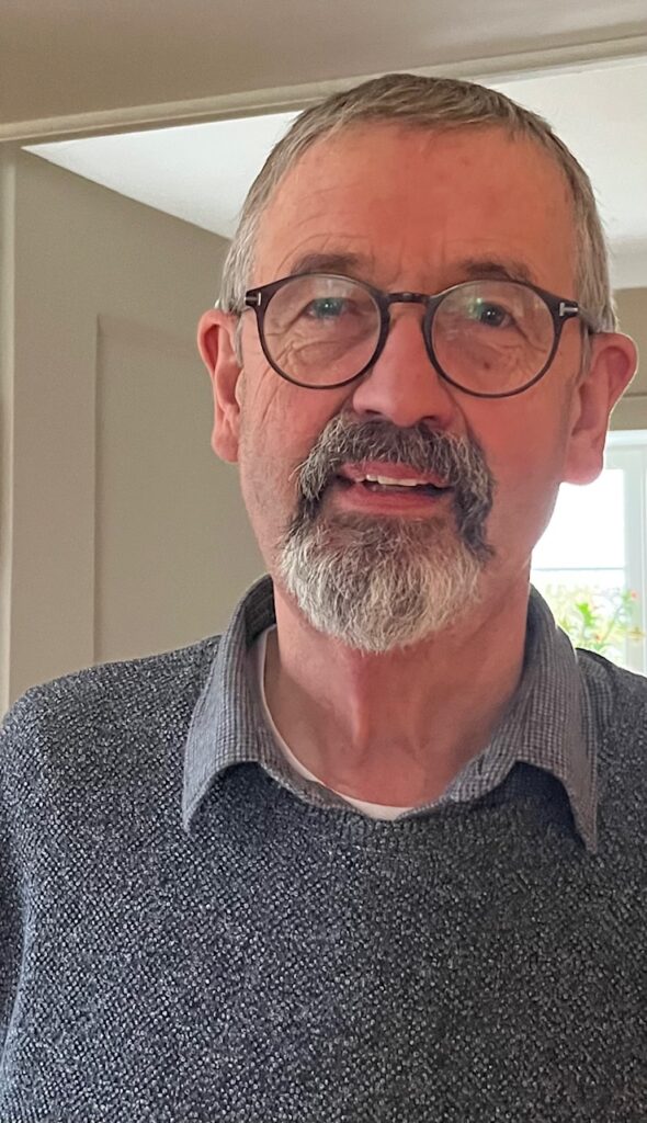 Reinhard Barthelmes mit Bart und Brille in gemütlicher Umgebung