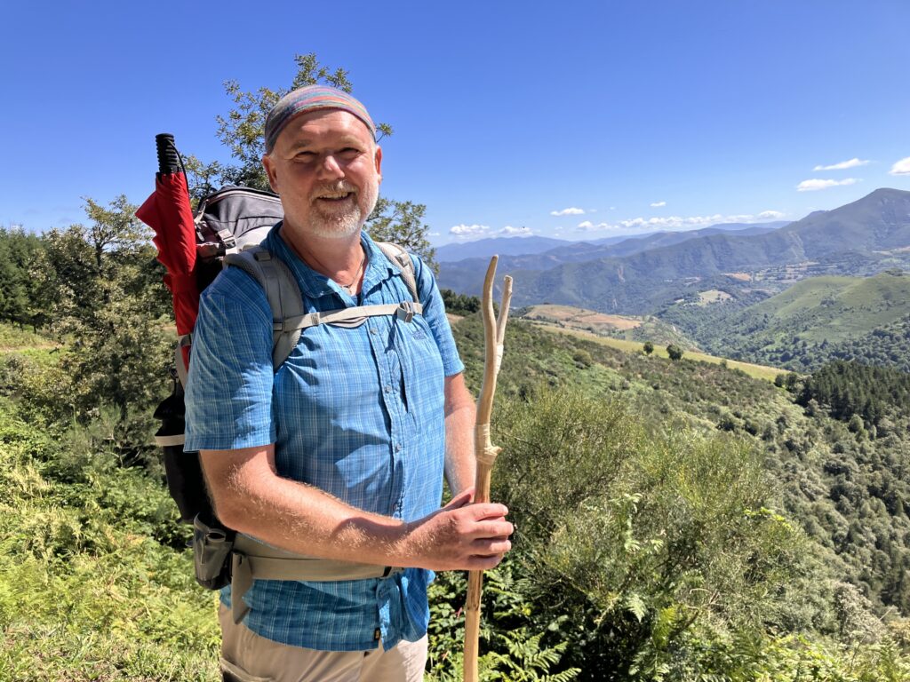 Michael Kaminski mit Rucksack und Wanderstock in der Natur